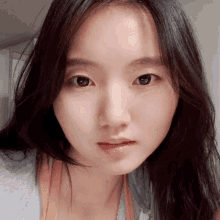 a close up of a woman 's face with a gray shirt