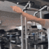 a person is using a machine in a gym and pointing at it