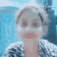 a close up of a woman 's face with a camera app on her phone .