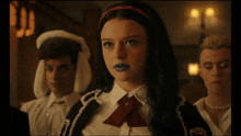 a girl with blue lipstick is standing in a room
