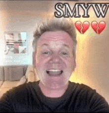 a man is taking a selfie with a broken heart in the background and smiling .
