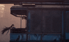 a person with wings is sitting in a blue bus