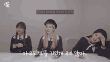three girls are sitting at a table with a sign that says twice on it