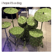a drum set wrapped in green wrapping paper and sitting on a tiled floor .