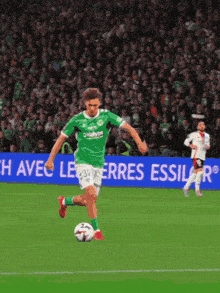 a soccer player kicking a ball in front of a sign that says " avec le erres essil "