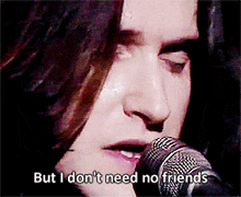 a man singing into a microphone with the words but i don 't need no friends