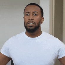 a man with a beard wears a white shirt