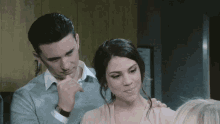 a man and woman are standing next to each other and the woman is smiling