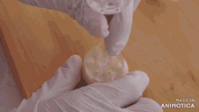 a person wearing white gloves wipes a cutting board with a towel