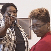 a man is pointing a gun at a woman while standing next to her .