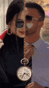 a man and a woman are standing next to each other and a pocket watch is hanging from a chain between them