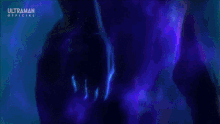 a purple light is coming out of a person 's hand in a dark room .