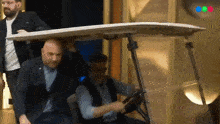 a man in a suit is driving a golf cart with a white top