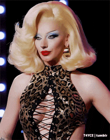 a woman with blonde hair is wearing a leopard print top and earrings