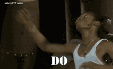 a man in a white tank top is dancing with his arms outstretched and the words `` do '' written on the screen .