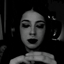 a black and white photo of a woman with dark lipstick and headphones