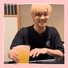 a man in a black shirt holds a glass of beer