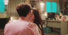 a man and woman kissing in front of a sign that says favor-hello_j