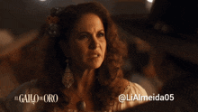 a woman with a flower in her hair and the words el gallo de oro on the top