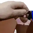 a close up of a person 's hand holding a doll 's head .