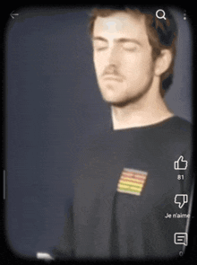 a man wearing a black shirt with a rainbow flag on the front is shown