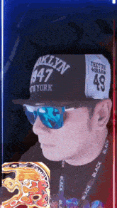 a man wearing sunglasses and a brooklyn 1947 hat