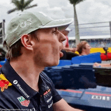 a man wearing a hat with red bull racing on it