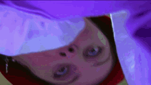 a close up of a person 's face with a purple cloth covering it