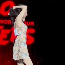 a woman in a dress is dancing in front of a red sign that says worms
