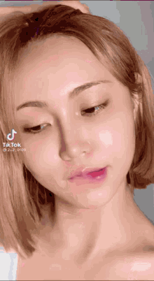 a close up of a woman 's face with tik tok written on the bottom right