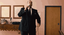 a man in a suit is singing into a microphone .