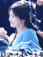 a woman wearing a blue dress and a blue headband