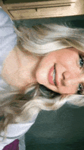 a woman with blonde hair and braces on her teeth is smiling .