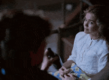 a woman in a white shirt is sitting next to a man in a blue and yellow plaid skirt .