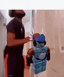 a man wearing a virtual reality headset is standing next to a roblox character wearing headphones .