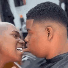 a man and a woman are kissing each other in a barbershop .
