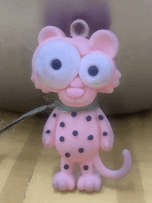 a pink toy with big eyes and polka dots on it