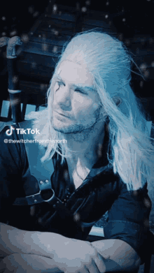 a man with long white hair and a black shirt has a tiktok account