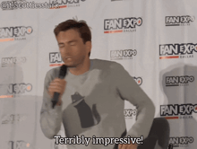 a man stands in front of a wall that says fan expo dallas