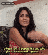 a woman is sitting at a table with her arms outstretched and talking to someone .