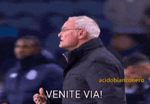 a man in a suit says venite via in a blurry photo