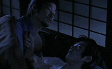 a man in a blue shirt is holding another man 's hand