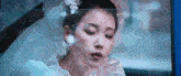 a woman in a wedding dress is sitting in a car