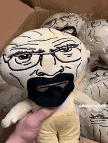 a person is holding a stuffed animal with a drawing of a man with glasses and a beard .