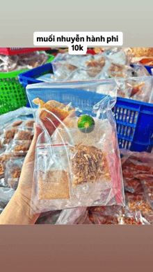 a person is holding a plastic bag of food with a lime in it .