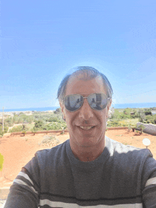 a man wearing sunglasses smiles for the camera