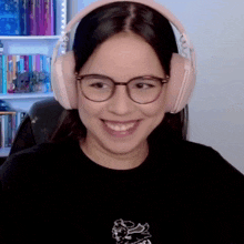 a woman wearing glasses and headphones is smiling in front of a bookshelf