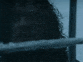 a close up of a monster with blue eyes holding a sword in the dark .