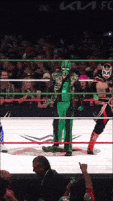 two wrestlers in a ring with a kia fc advertisement in the back