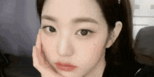a close up of a girl 's face with her hand on her face .